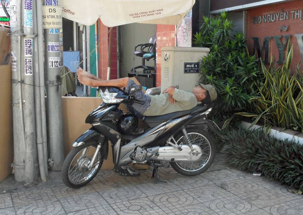 Vietnamese schläft auf seinem Roller in Ho Chi Minh Stadt